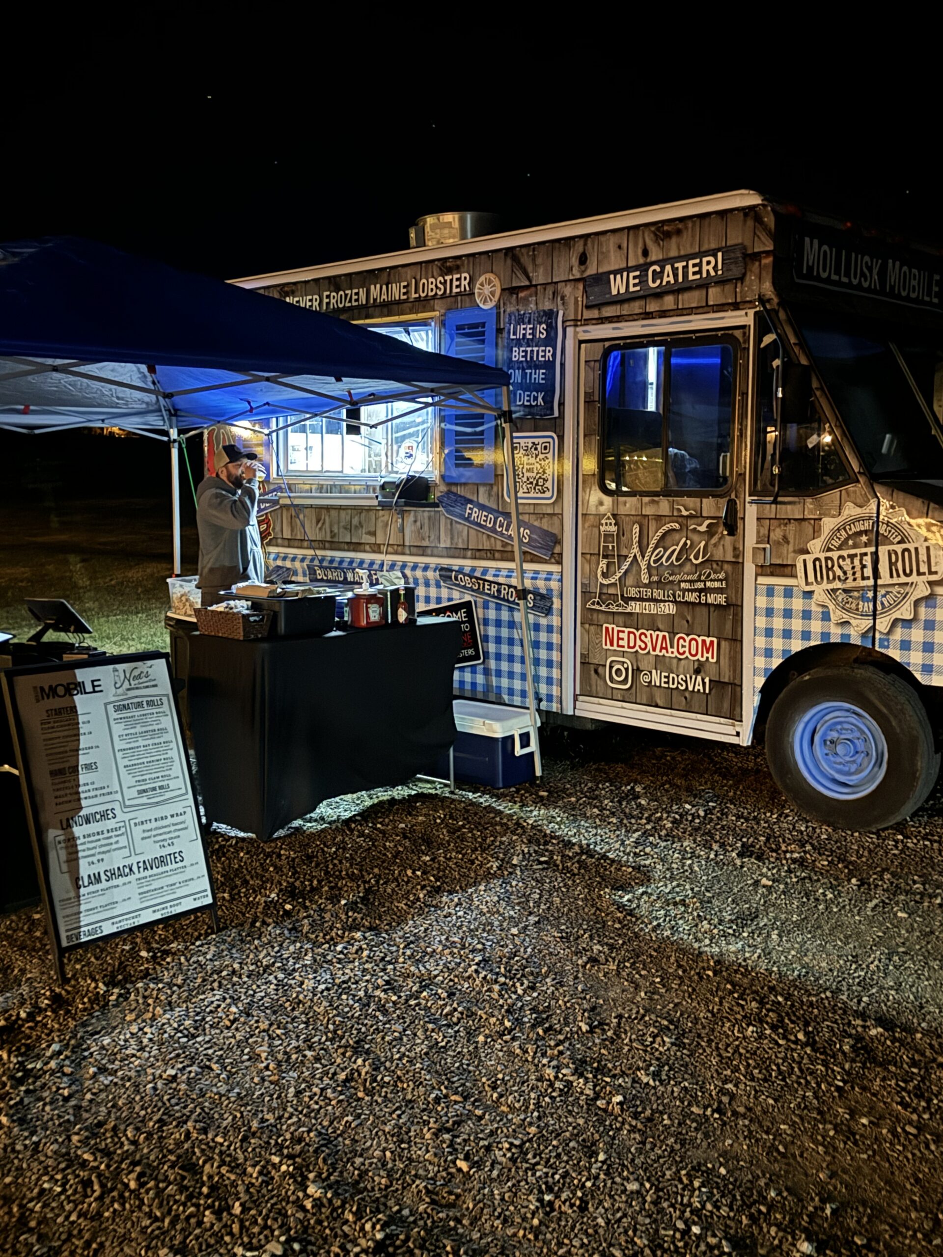 Ned's Mollusk Mobile food truck illuminated and serving after dark